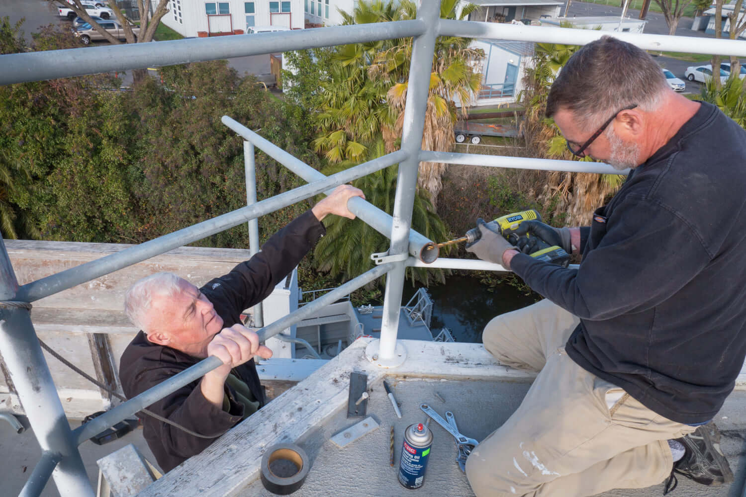 Volunteers repairing and maintaining the upper deck of the USS Lucid.