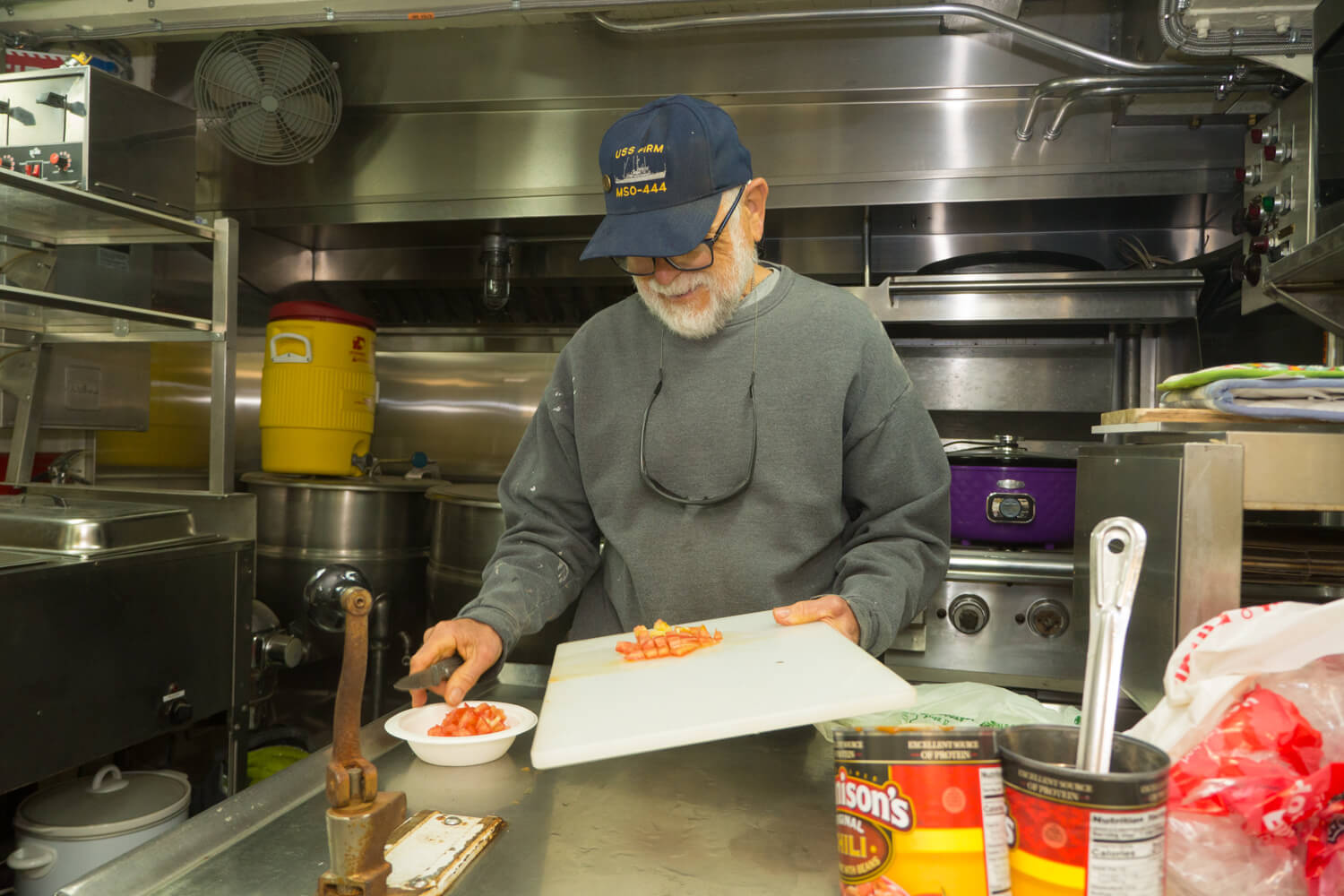 Volunteer preparing food in the USS Lucid galley during a volunteer event.