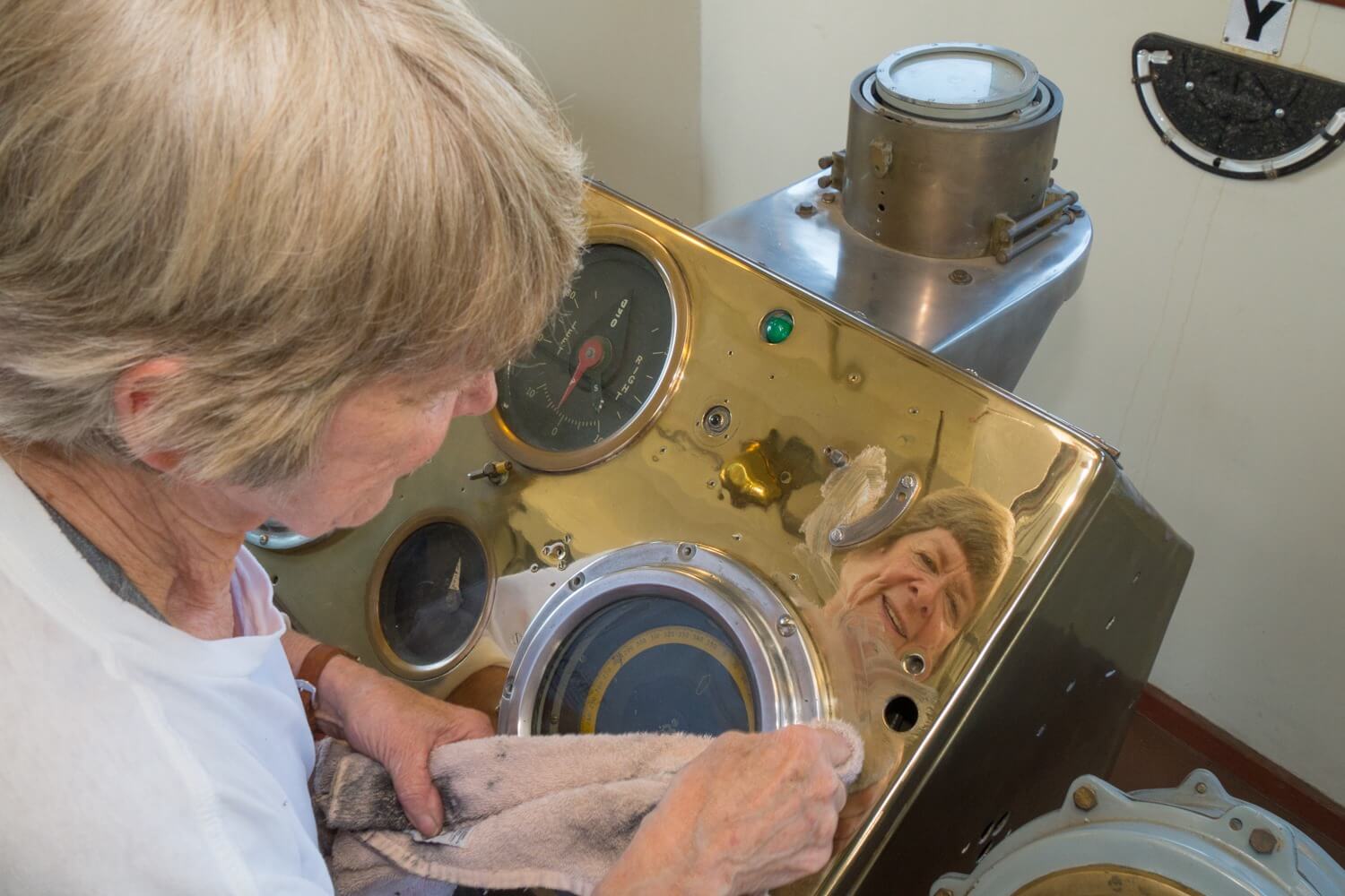 Volunteer restoring historic navigation and control instruments aboard the USS Lucid.