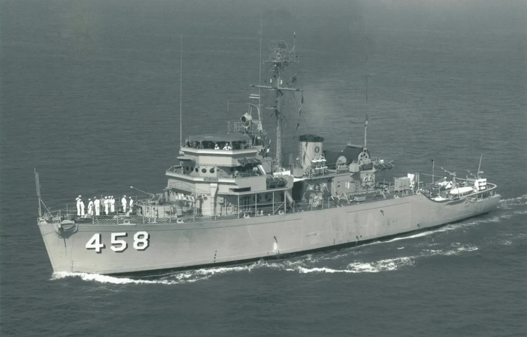 Historic photograph of the USS Lucid (MSO-458) underway at sea during her active U.S. Navy service, showing the Aggressive-class oceangoing minesweeper with her crew on deck.