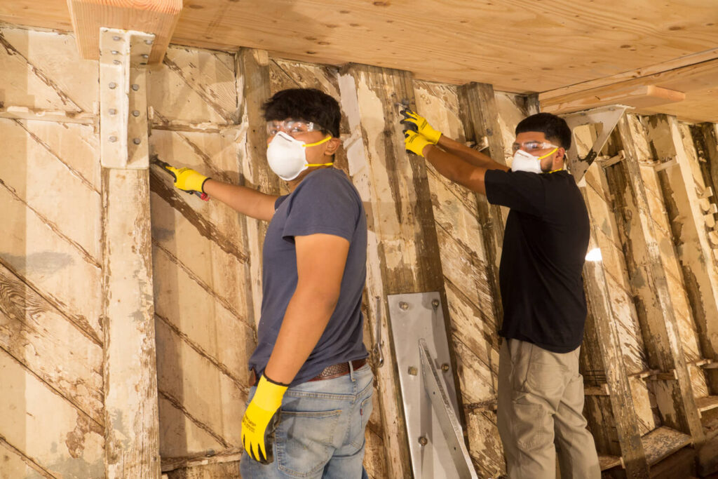 Volunteers performing restoration work inside the USS Lucid.
